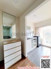 Bright interior view of a modern apartment living space with built-in shelving and large windows