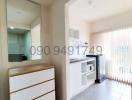 Bright interior view of a modern apartment living space with built-in shelving and large windows