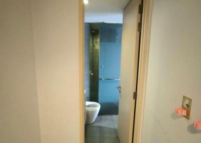 Compact bathroom viewed from the hallway with a sliding door and tiled flooring