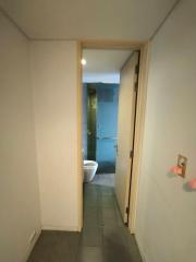 Compact bathroom viewed from the hallway with a sliding door and tiled flooring