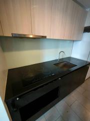 Modern kitchen with wooden cabinets, black countertop, and built-in appliances