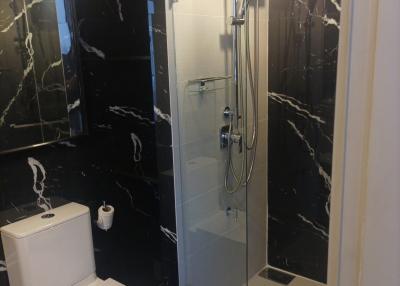 Modern bathroom interior with glass shower and marble tiles