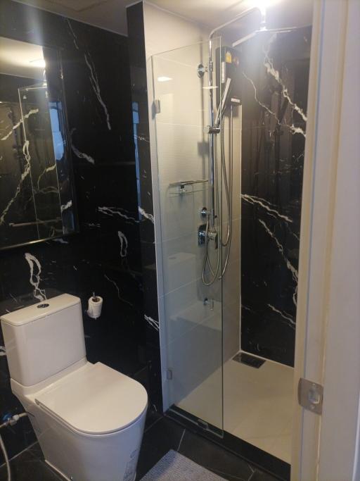 Modern bathroom interior with glass shower and marble tiles