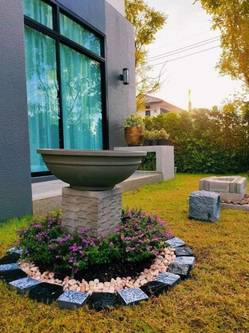 Modern house exterior with garden and decorative fountain