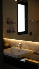 Modern bathroom with stylish sink and illuminated mirror