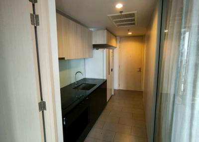 Compact galley kitchen with modern appliances and tiled flooring
