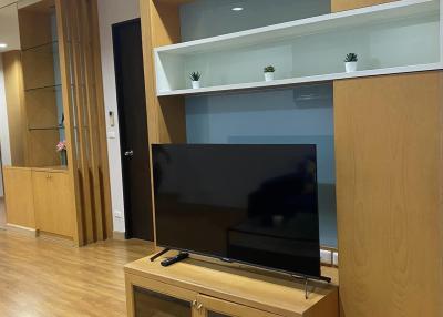 Modern living room with wooden furniture and wall-mounted shelves