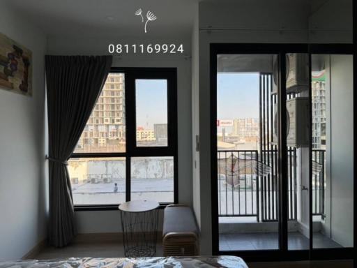 Cozy bedroom with balcony access and a view of the city