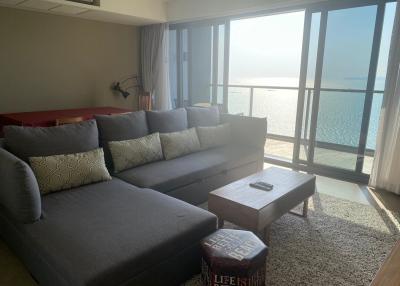 Spacious living room with a large window overlooking the sea