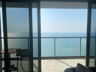 Seaside balcony with a panoramic ocean view and seating