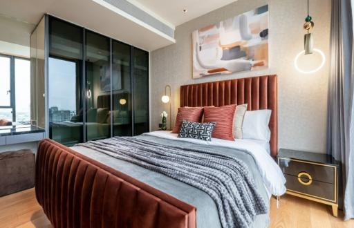 Modern bedroom with large bed and artwork in a luxury apartment