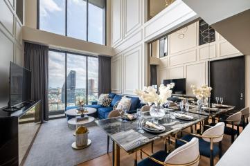 Luxurious living room with city view, high ceilings, and elegant furnishings