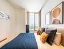 Modern bedroom with large windows and art on the walls