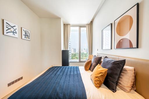 Modern bedroom with large windows and art on the walls