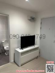 Compact living space with television and bathroom entry