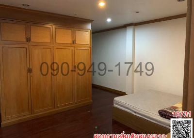 Spacious bedroom with a large wardrobe and well-lit ambiance