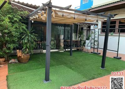Spacious covered patio with artificial turf and comfortable outdoor seating