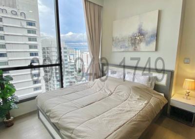 Modern bedroom with a large window offering city views