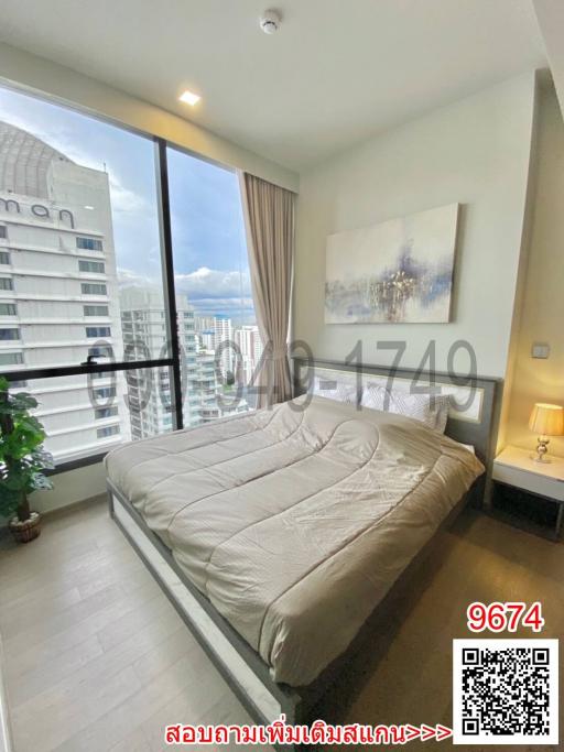 Modern bedroom with a large window offering city views