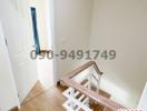 Bright staircase area leading to the upper floor of a residential property with wooden banisters
