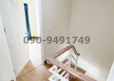 Bright staircase area leading to the upper floor of a residential property with wooden banisters