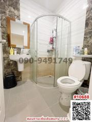 Modern bathroom with glass shower enclosure and well-lit mirror