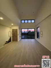 Spacious living room with high ceiling and large windows