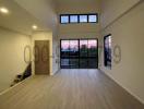 Spacious living room with high ceiling and large windows