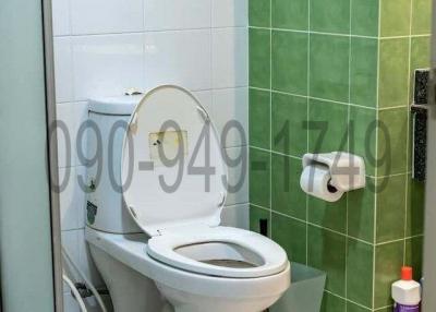 Compact bathroom with toilet and tiled walls