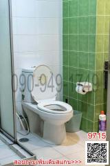 Compact bathroom with toilet and tiled walls