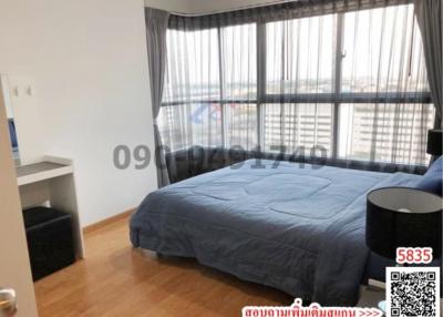 Spacious bedroom with large windows and city view