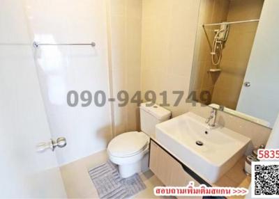 Modern bathroom interior with clear glass shower division, white ceramic toilet, and sink