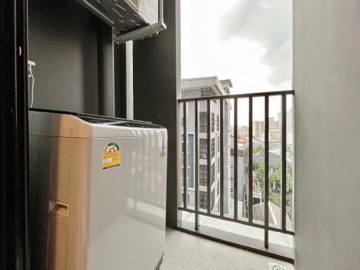 Compact balcony with a city view and washing machine