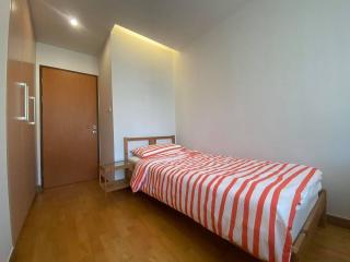 Cozy bedroom with wooden flooring and a single bed with striped bedding