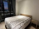 Cozy bedroom with a double bed and city view at dusk