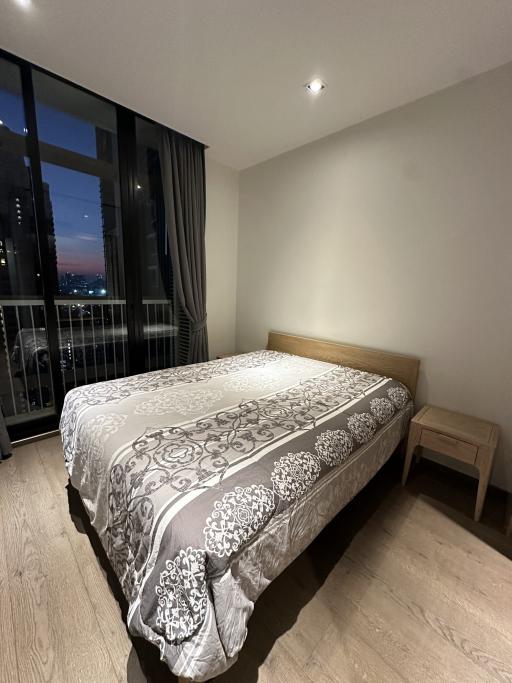 Cozy bedroom with a double bed and city view at dusk