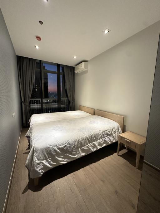 Cozy bedroom with a large bed and city view at dusk