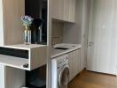 Modern laundry room with washing machine and built-in cabinets