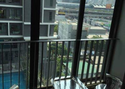 High-rise apartment balcony with city view and seating arrangement