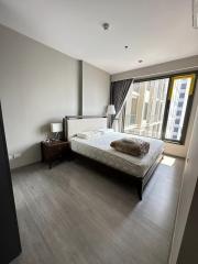 Modern bedroom with a large bed and natural light from window