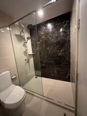 Modern bathroom with glass shower enclosure and elegant dark wall
