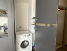 Compact laundry area with a modern washing machine and built-in shelves