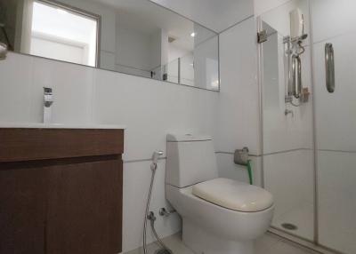 Modern bathroom with white ceramic fixtures and wooden vanity