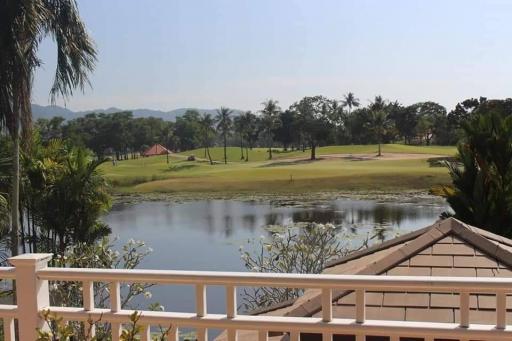 Scenic view from balcony overlooking a golf course with a lake