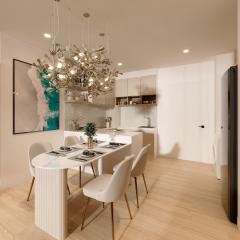 Modern kitchen with dining area, artistic lighting, and wood flooring