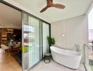 Modern bathroom with freestanding tub by large window