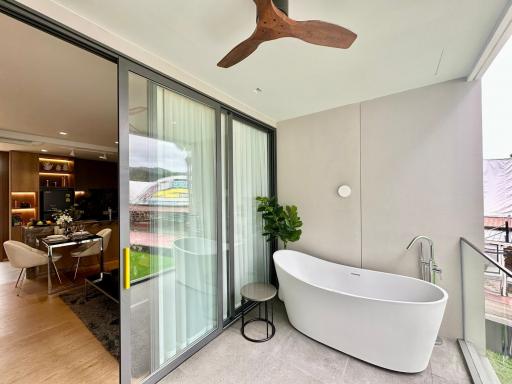 Modern bathroom with freestanding tub by large window
