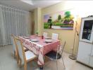Cozy dining room with table set for dinner and a colorful countryside painting on the wall