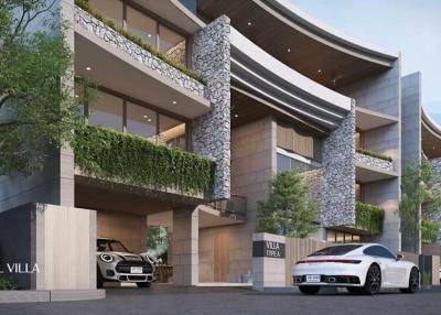 Exterior view of a modern villa with cascading design and natural stone accents, featuring lush greenery and a luxury car parked outside