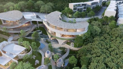 Aerial view of a modern, curvilinear building surrounded by lush greenery